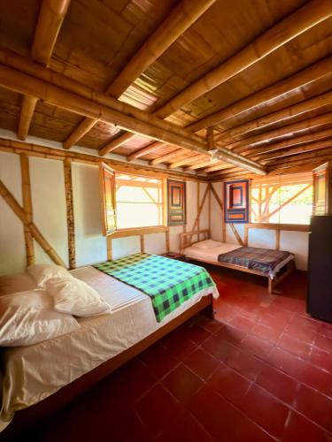 a bedroom with two beds in a room with wooden ceilings at La orquídea campestre in Montenegro