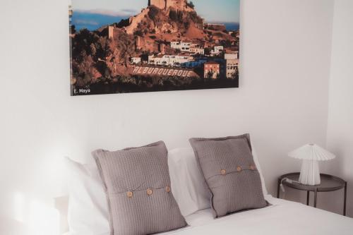 a bedroom with a bed with a picture on the wall at Las Chavitas Rural Apartamentos turísticos in Alburquerque