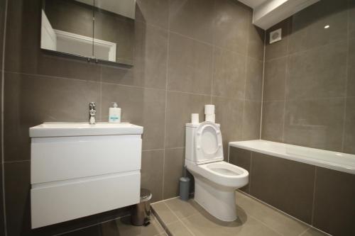 a bathroom with a toilet and a sink at Osterley Place - Apt A in Hounslow