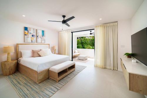 a bedroom with a bed and a television in it at New Stylish 2BR Villa Walk to Beach Pool in Saint James