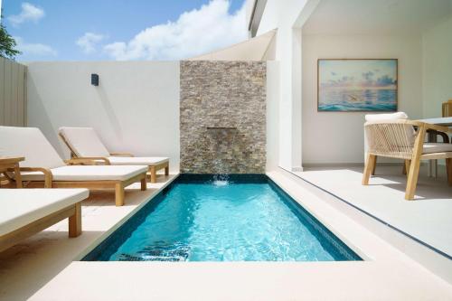 an indoor swimming pool with chairs and a fireplace at New Stylish 2BR Villa Walk to Beach Pool in Saint James