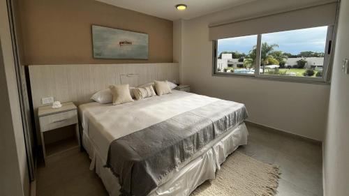 ein Schlafzimmer mit einem großen Bett und einem Fenster in der Unterkunft LS Apart Hotel in Martin Miguel de Güemes International Airport