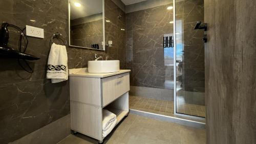 ein Badezimmer mit Waschbecken und Dusche in der Unterkunft LS Apart Hotel in Martin Miguel de Güemes International Airport