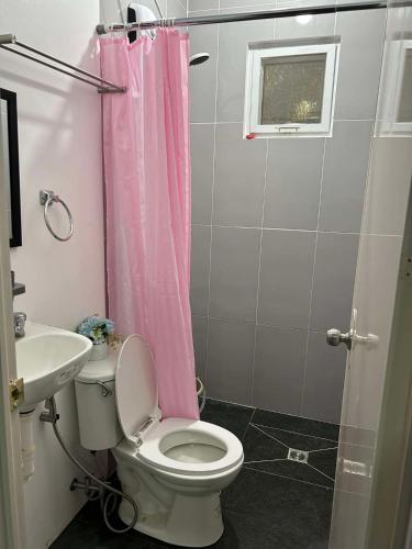 a bathroom with a pink shower curtain and a toilet at Starksway Resort in San Juan