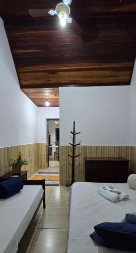 a bedroom with two beds and a wooden ceiling at Casa Manga Rosa in Paraty