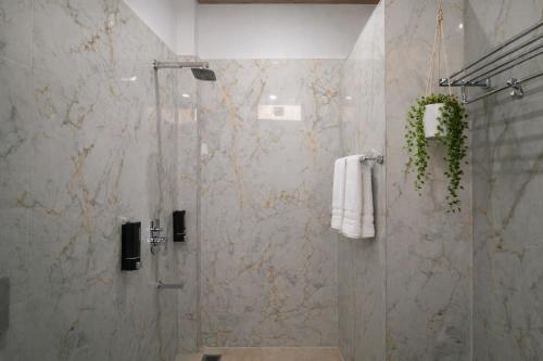 a bathroom with a shower with a glass door at Moon and Root in Narendranagar