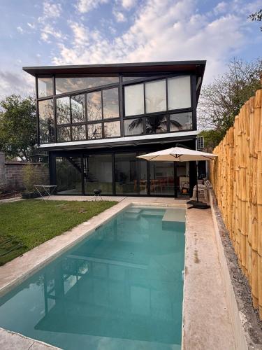 a house with a swimming pool in front of it at Jungle surf Villa in El Zonte