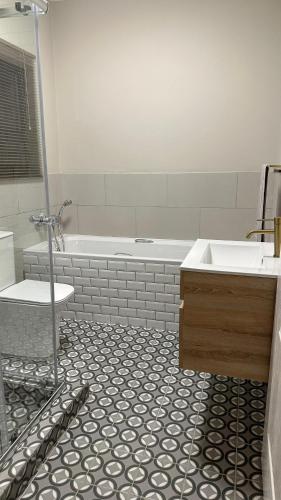 a bathroom with a shower and a sink and a tub at De Guest Suites in Eversdal