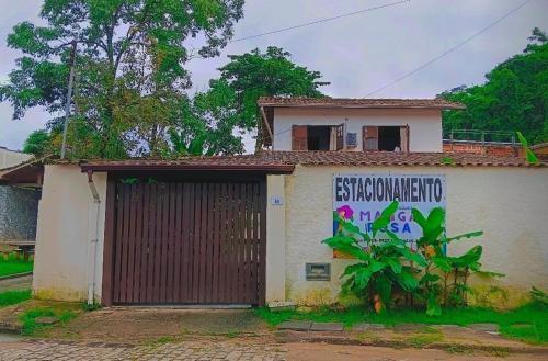 a house with a garage with a sign on it at Casa Manga Rosa in Paraty