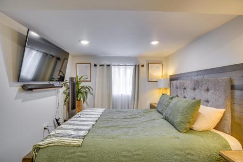 a bedroom with a bed with a television on the wall at Work & Explore Downtown Tacoma! Convenient Condo in Tacoma