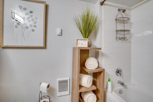 a bathroom with a white tub and a wooden shelf at Work & Explore Downtown Tacoma! Convenient Condo in Tacoma