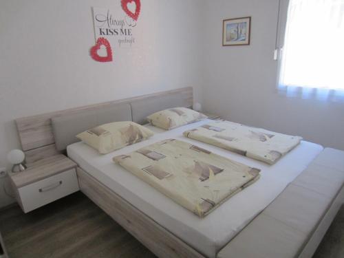 a white bed with two pillows on it in a room at APARTMAJI VALTER in Srpenica