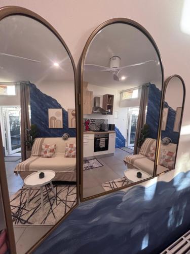 a living room with two mirrors in a room at Studio Bleu tout équipé au calme proche des commerces in Briord