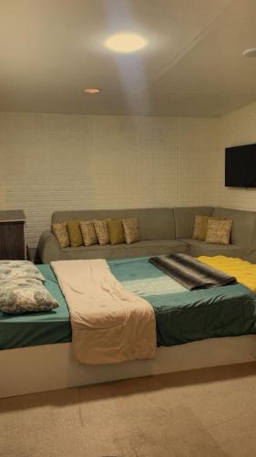 a large bed in a room with a couch at Lozi House Cozy Stay in Al Azraq ash Shamālī