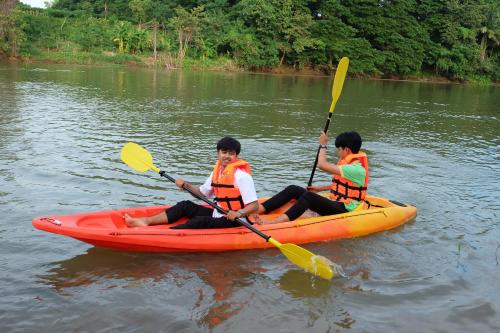 two people in a kayak on a river at Princess River Kwai Hotel in Kanchanaburi