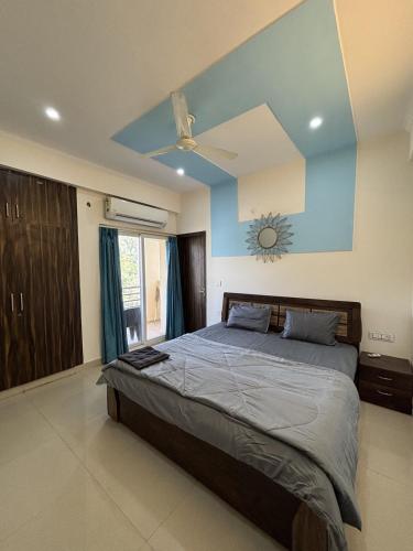 a bedroom with a large bed with a blue wall at The Huddle - Dawn in Dehradun