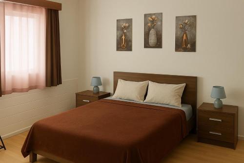 a bedroom with a bed with three pictures on the wall at Espaço perto aeroporto in Ponta Delgada