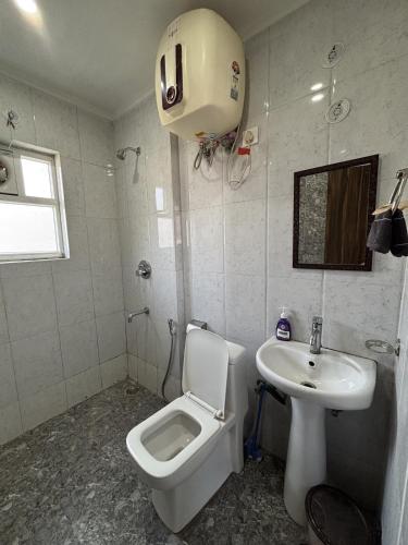a bathroom with a toilet and a sink at The Huddle - Dawn in Dehradun