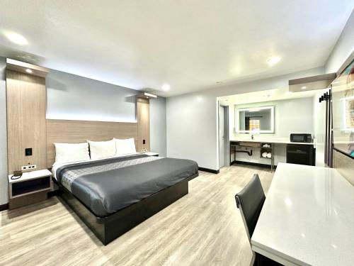 a hotel room with a bed and a table at Express Inn & Suites Ontario Airport in Ontario