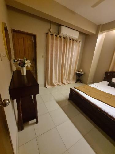 a bedroom with a bed and a table and a window at Couple room, attached balcony in Safipur