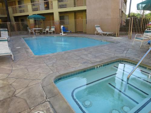 a swimming pool in a courtyard with chairs and tables at Country Inn Ontario in Ontario