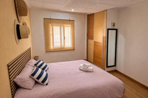 a bedroom with a bed with two pillows and a window at Casa Caloret - Playa y centro a 2 min in Vinarós