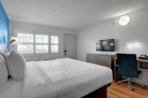 a bedroom with a bed and a desk and a chair at Signature Inn Medford Downtown - Newly Renovated in Medford