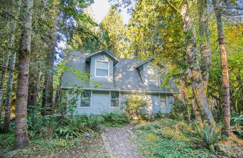 a house in the middle of a forest of trees at Mountain Meadows Inn & Chalet Suites in Ashford