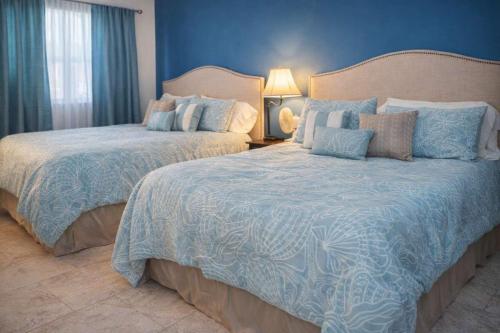 two beds in a bedroom with blue walls at Gulfview II #410 Luxe in South Padre Island