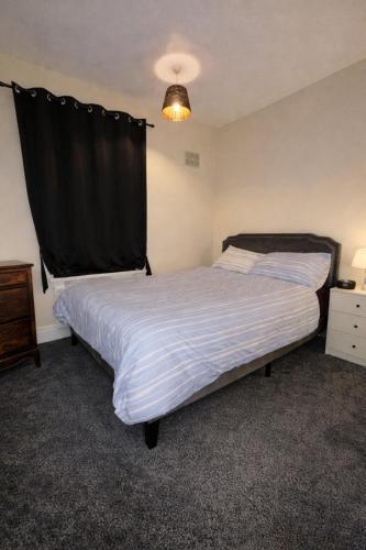 a bedroom with a large bed with a black curtain at Cozy Private Blackout Room in Longley