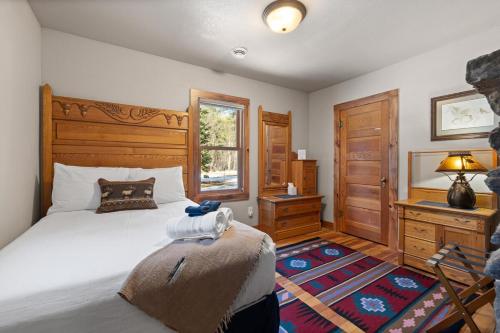a bedroom with a bed and a desk and a window at Grizzly Bear Creek- Mt Rushmore Views- Hot tub in Keystone