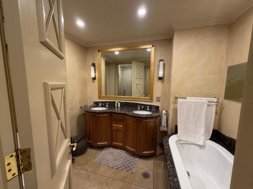 a bathroom with two sinks and a tub and a mirror at Michelangelo Towers in Johannesburg