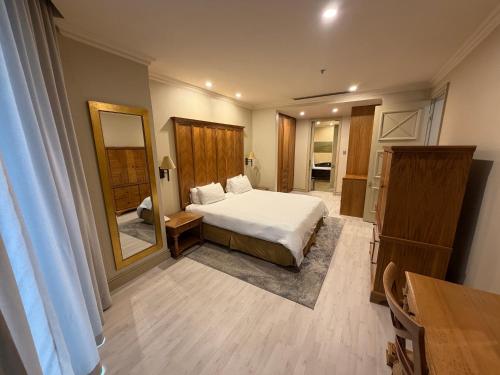 a bedroom with a bed and a large mirror at Michelangelo Towers in Johannesburg