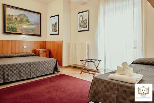 a hotel room with two beds and a red rug at Nazareth Residence in Viterbo