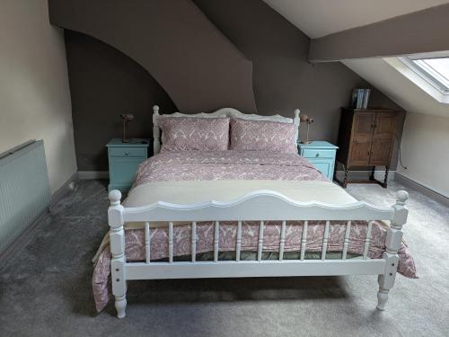 a bedroom with a white bed in a attic at Heart of Hebden in Hebden Bridge