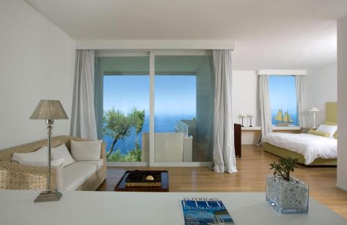 a living room with a bed and a large window at Relais Blu in Massa Lubrense