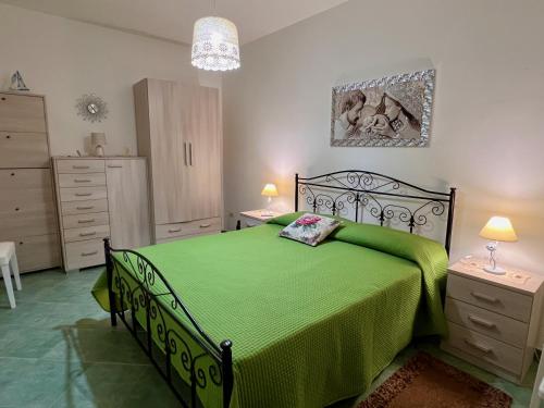 a bedroom with a green bed in a room at Villetta Capilungo by Paf in tour in Capilungo