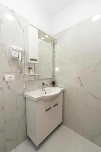 a white bathroom with a sink and a shower at Guesthouse 3 Diamonds in Omarë