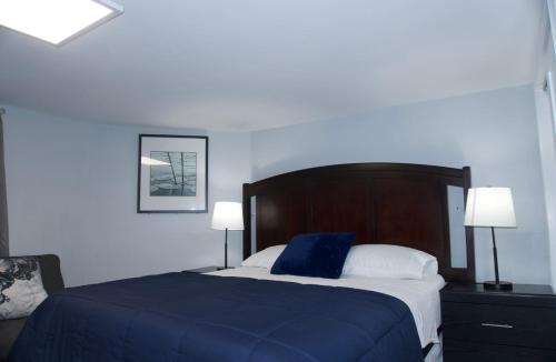 a bedroom with a bed with a blue blanket and two lamps at Basemant private room 21 in Guttenberg