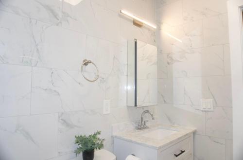 a white bathroom with a sink and a toilet at Basemant private room 21 in Guttenberg