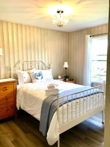 a bedroom with a white bed and a chandelier at 8 Clarence Ln in Cavendish