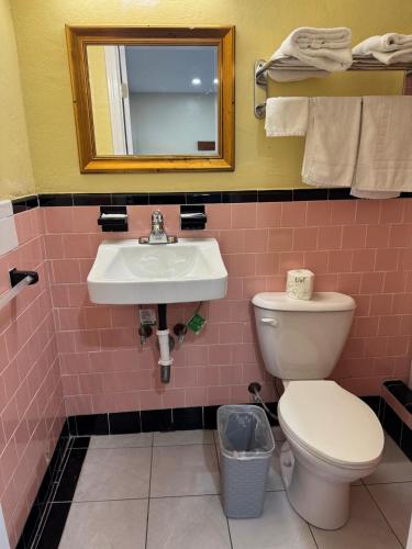 a bathroom with a sink and a toilet and a mirror at James Motel in Saugus