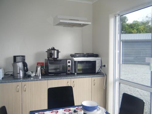 a kitchen with a microwave and a table with chairs at Charleston Lodge in Charleston