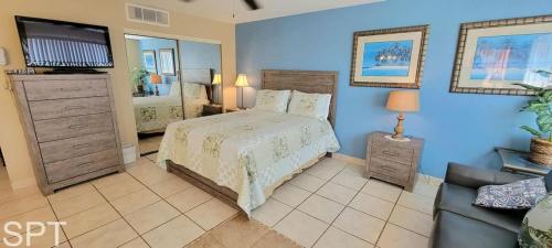 a bedroom with a bed and a tv and a couch at Great Pool - Beach Access - Small Family Perfect in South Padre Island