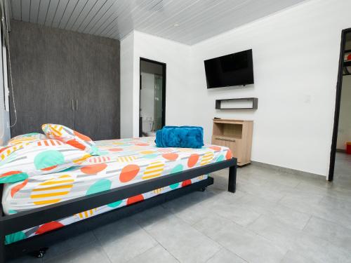 a bedroom with a bed and a flat screen tv at Valle de las Bendiciones, Lago Calima in Calima
