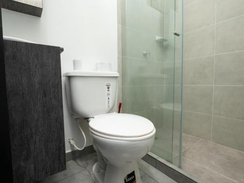 a bathroom with a toilet and a glass shower at Valle de las Bendiciones, Lago Calima in Calima