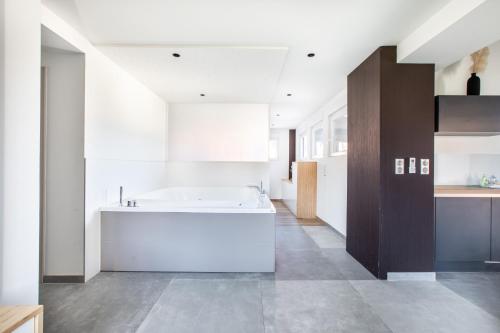 a bathroom with a tub and a sink in a room at Gite Spa L'Atelier Emile - Spa Privatif - 5 min COLMAR in Sainte-Croix-en-Plaine