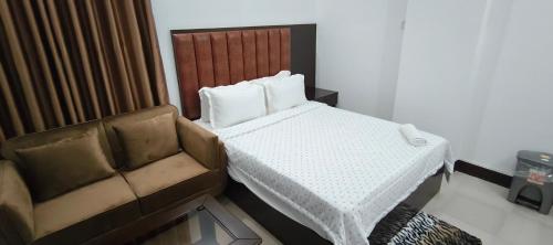 a bedroom with a bed and a couch at Park Amaira Banani Guesthouse in Dhaka