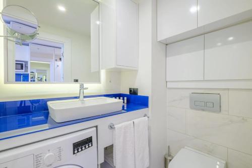 a white bathroom with a sink and a mirror at best VIP HOTEL panorama suites IN batumi R in Batumi