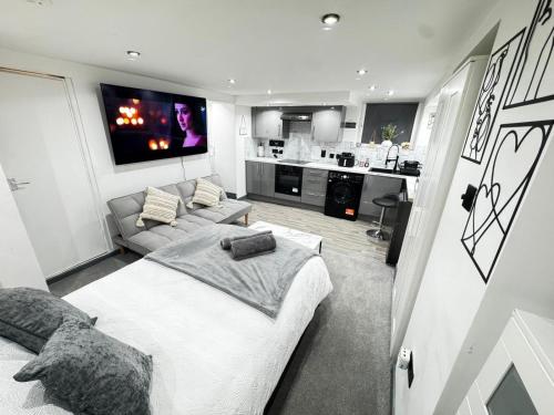a bedroom with a bed and a couch and a kitchen at Royal Noor Escape in Killingbeck